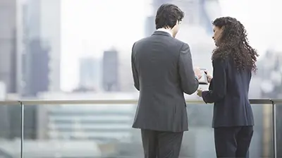 Two business people looking at a tablet on a rooftop